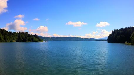 Tranquil Lake Surrounded by Majestic Mountains and Clear Sky wallpaper