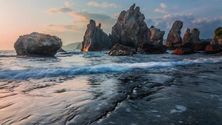 Majestic Waves Against Rocky Shoreline wallpaper