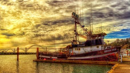 Sunset Serenity of a Fishing Boat by the Bridge wallpaper