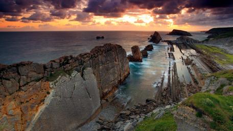 Majestic Sunset Over Rocky Coastline wallpaper