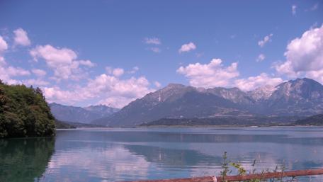 Serene Lake Amidst Majestic Mountains and Blue Skies wallpaper