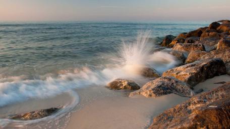 Gentle Waves Crashing on Rocky Shoreline wallpaper