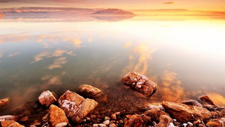 Serene Sunrise Over Tranquil Lake Shoreline wallpaper