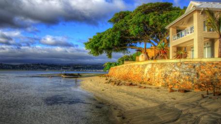 Coastal Serenity Embraced by Nature and Cloudy Skies wallpaper