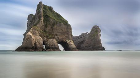 Majestic Coastal Rock Formation in Tranquil Waters wallpaper