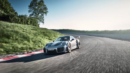 Sleek Porsche Racing on a Scenic Track wallpaper