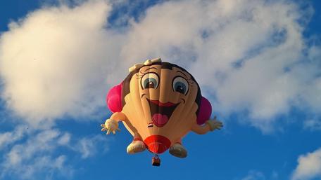 Playful Hot Air Balloon Soars Above the Clouds wallpaper