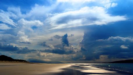 Serene Beach Under Dramatic Skies wallpaper