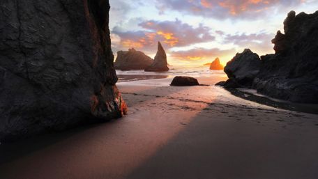 Sandy beach with huge rocks wallpaper