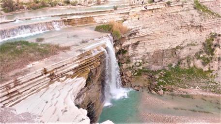 Serene Waterfall Amidst Rocky Cliffs wallpaper