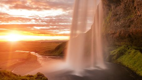 Behind the Seljalandsfoss waterfall at midnight sun wallpaper