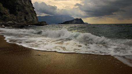 Serene Beach Waves Under Cloudy Skies wallpaper
