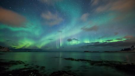 Green aurora borealis on the starry night sky wallpaper