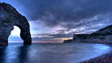 Cloudy sky over Durdle Door wallpaper