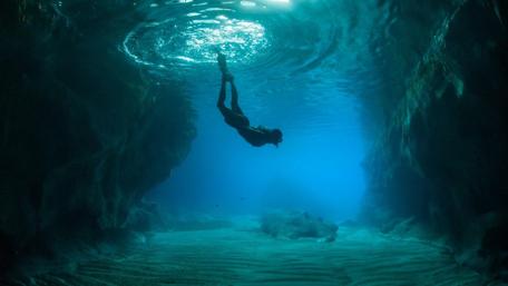Diver in Sunlit Sea Cave wallpaper