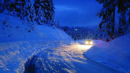Car headlights in snowy night wallpaper
