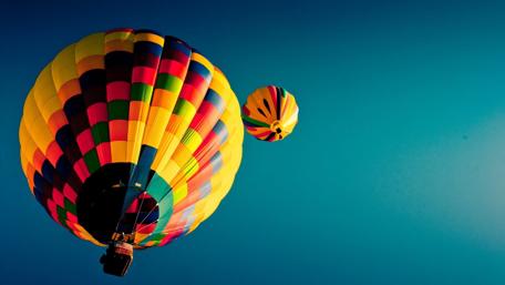 Vibrant Hot Air Balloons Soaring High Above Blue Skies wallpaper