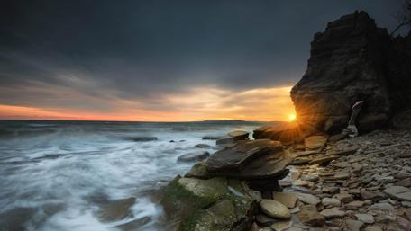 Majestic Sunset Over Rocky Shoreline wallpaper