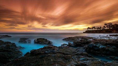 Serene Sunset Over Rocky Beach wallpaper