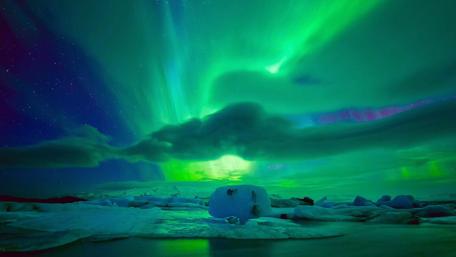 Mesmerizing Aurora Borealis Above Icy Landscape wallpaper