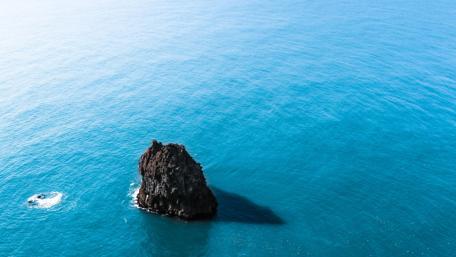 Small rock islet in the blue sea wallpaper