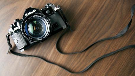 Vintage Camera on a Wooden Desk Surface wallpaper