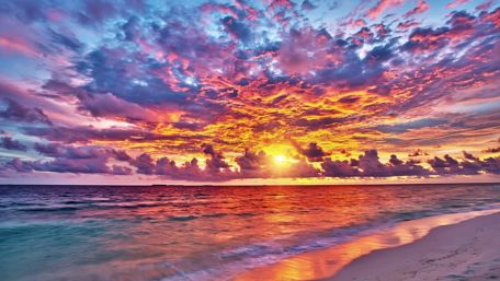 Vibrant Sunset Over Serene Ocean Shoreline wallpaper