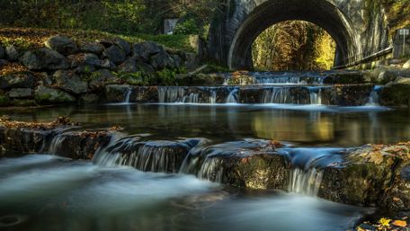 Serene Waterfall Flowing Through a Woodland Scene wallpaper