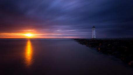 Serene Lighthouse at Dusk Over Calm Sea wallpaper