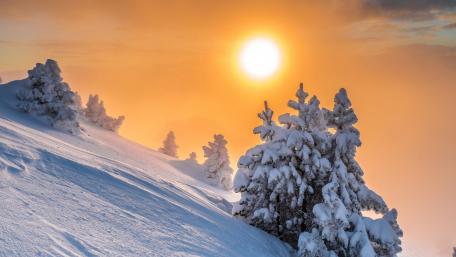 Serene Winter Sunrise Over Snowy Mountainside wallpaper