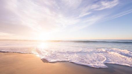Sunrise on the horizon of a beach wallpaper