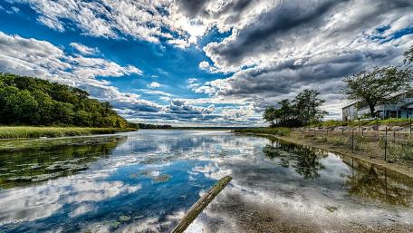 Serene River Reflection Under a Dramatic Sky wallpaper