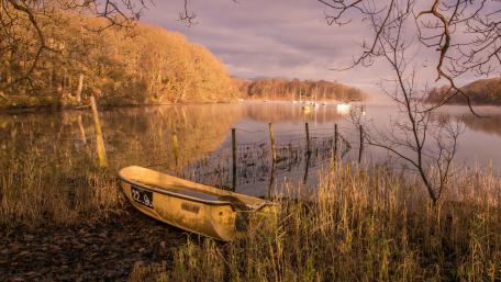 Tranquil Lake Scene with a Lonely Boat wallpaper