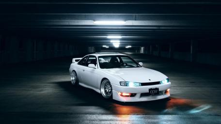Sleek White Sports Car in an Urban Garage Setting wallpaper