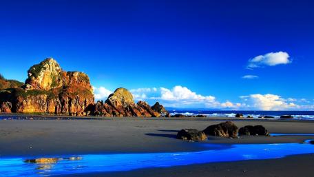 Serene Coastal Landscape Under a Brilliant Blue Sky wallpaper