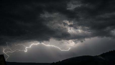 Dramatic Thunderstorm Over Dark Landscape wallpaper