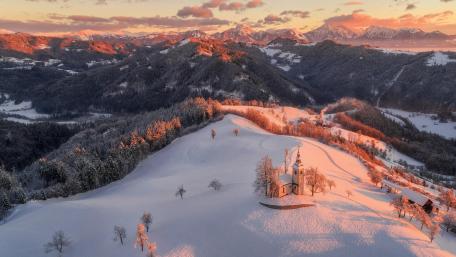Snowy Saint Thomas church at the hilltop in Slovenia wallpaper