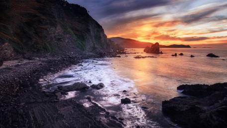 Serene Coastal Sunrise Over Gentle Waves wallpaper
