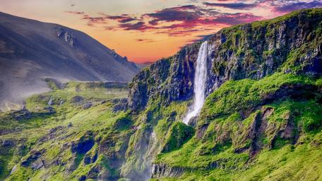 Majestic Waterfall Surrounded by Scenic Mountains wallpaper