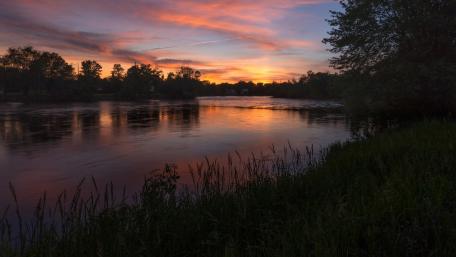 Serene Sunset Over Tranquil River Banks wallpaper