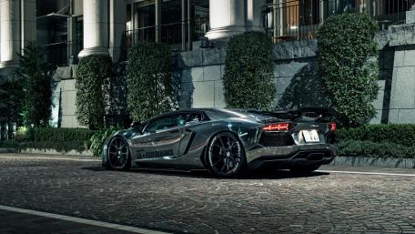 Black Lamborghini Aventador in a cobblestone road wallpaper