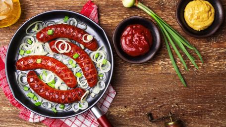 Sizzling Kielbasa in a Pan with Fresh Ingredients wallpaper