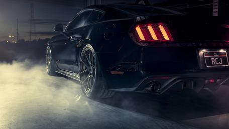 Sleek Black Muscle Car in Action wallpaper