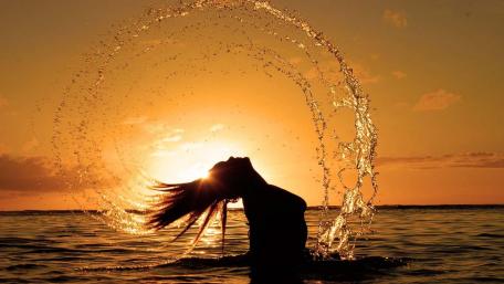 Golden Sunset Silhouette of Joyful Woman in Water Brilliance wallpaper