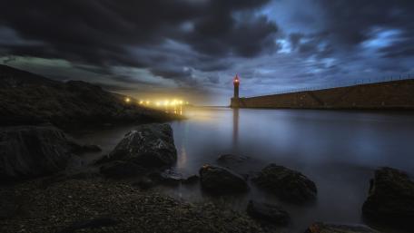 Lighthouse Illuminating the Night Sky wallpaper