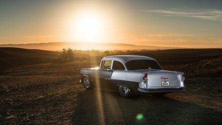 Classic Car at Sunset Over Rolling Hills wallpaper