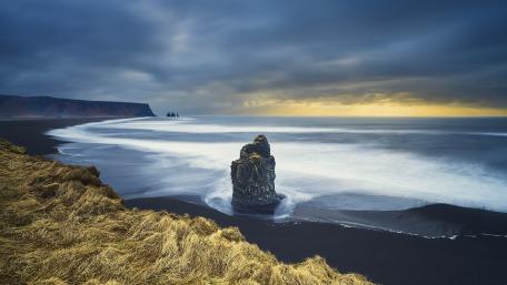 Serene Coastal Escape Amidst Cloudy Skies wallpaper