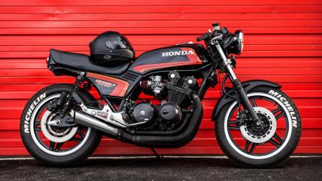 Classic Honda Motorbike Against Red Background wallpaper
