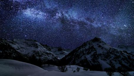Starry Winter Night over Snowy Mountains wallpaper