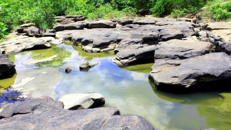 Serene Pond Surrounded by Majestic Rocks in Nature's Embrace wallpaper